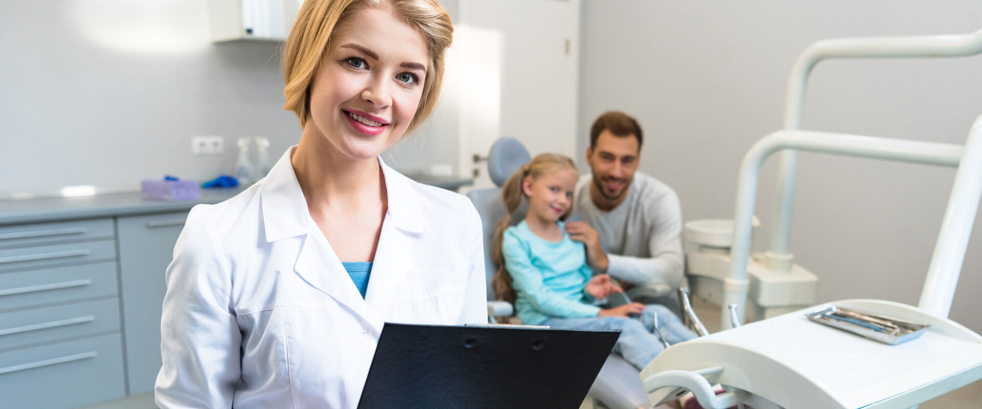 Beautiful female dentist with clipboard looking at camera